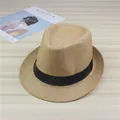 Detailed view of a classic straw fedora hat with a black ribbon band on a wooden table. - Khaki (Ribbon)