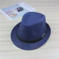 Detailed view of a blue straw fedora hat with a black buckled leather band on a table. - Navy Blue (Leather Belt)