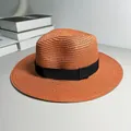 Close-up detail of a burnt orange woven straw Panama hat with a stylish black ribbon band. - One Size Adjustable / Ribbon Style (Detachable Ribbon) / Caramel color