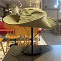 Detailed close-up of a green outdoor sun hat with an embroidered logo on a stand - M (56-58cm) / Grey Green