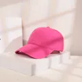 Detaillierte Seitenansicht einer rosa Baumwoll-Baseballkappe auf einem weißen Stand - M (56-58cm) / Fuchsia