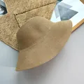 Detailed close-up view of a minimalist woven straw sun hat for women on a neutral mat - Adjustable (56-58cm) / Khaki