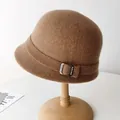 Elegant brown wool cloche hat for women with decorative buckle on wooden stand - Adjustable / Camel