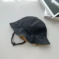 Detail of retro black denim bucket hat with adjustable drawcord and metal eyelets - Reversible / Black and Khaki