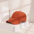 Detailansicht einer orangefarbenen Baumwoll-Baseballkappe auf einem weißen Sockel. - M (56-58cm) / Rostrot