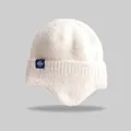 Detailed macro view of the white knitted winter earflap beanie with a snowflake tag - Elastic Circumference (56-59cm) / Milky White