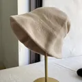 Side view of a premium beige wool bucket hat on a minimalist gold stand - M (56-58cm) Adjustable / Beige