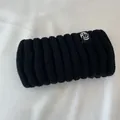 Primo piano di spessa fascia in maglia a coste nera con calda lana e etichetta logo - Nero