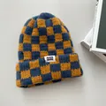 Nahaufnahme einer gelb-blauen Strickmütze mit Karomuster und dicker Wollstruktur. - Elastischer Umfang / Marineblau Kariert