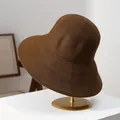 Close-up of the woven texture and wide brim of a brown foldable women's straw sun hat. - M (56-58cm) / Coffee