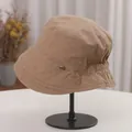 Close-up detail of khaki cotton bucket hat with retro pleated design and metal tag - Adjustable (56-58cm) / Camel