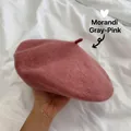 Close-up of a dusty rose wool beret held by hand against a white fabric background. - M (56-58cm) / Morandi Dusty Pink