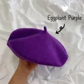 Close-up of a vibrant purple wool beret held against a white fabric background - M (56-58cm) / Eggplant Purple