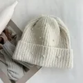 Detailed view of the soft knitted texture and pearl decorations on the cream beanie. - Hat Circumference (53-60cm) Elastic / Off White