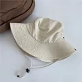 Détail d'un chapeau bob beige à séchage rapide avec mentonnière réglable pour le soleil - Circonférence Adulte / Beige
