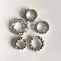 Macro view of five silver-plated alloy ear cuffs featuring twisted and chain link details. - Silver Jewelry Set / Silver