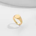 Close-up detail of a minimalist gold-colored signet ring with a smooth circular top. - Size 7 / Round Flat Top Style (A16-4-3-5)