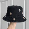 Close-up of embroidered seashell pattern on a black denim children's bucket hat. - Black Pink Shell