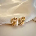 Close-up macro detail of elegant golden flower on natural white baroque pearl earrings - November - Chrysanthemum