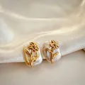 Close-up view of the elegant 18K gold flower design on natural baroque pearl earrings - March - Daffodil