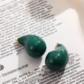 Gros plan de boucles d'oreilles clous en émail vert foncé brillant en forme de goutte. - Vert Foncé