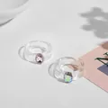 Detailansicht von zwei Acrylringen mit funkelnden rosa und irisierenden Edelsteinen. - Transparenter Rosa Irisierender Quadratischer Edelstein (R180_1) / Zweiteiliges Set