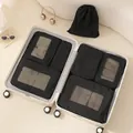 Set of 7 black Taslon travel packing cubes organized neatly inside a white suitcase - Black