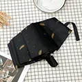 Automatic black umbrella with gold feather pattern and three-fold portable design. - 8-Rib Automatic Bronzing Feather / Black