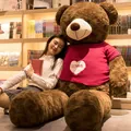 Oversized brown teddy bear plush toy wearing a pink knit sweater with a white heart - Rose Velvet Dark Brown + Heart Sweater / 100cm