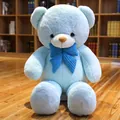 Großer hellblauer Teddybär aus Plüsch mit Kord-Schleife auf Holzboden im Innenraum - Blau / 80cm