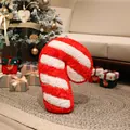 Plüschiges rot-weiß gestreiftes Weihnachtszuckerstangen-Kissen in festlicher Umgebung. - Rote Zuckerstange