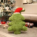 Plüsch-Weihnachtsbaum-Kissen mit süßem Lächeln und Nikolausmütze in gemütlichem Zimmer - Weihnachtsbaum