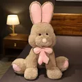 Large brown plush rabbit toy with pink long ears and a cute pink bow on a cozy bed - Brown Rabbit / 50cm