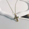 Primo piano dettagliato di una collana con croce dorata e zirconi multicolore vivaci - 45+5cm / Oro
