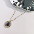 Vintage-Halskette aus Edelstahl mit ovalem blauem Steinanhänger und Kristallakzenten. - Oval Lapislazuli Stil