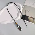 Elegante Lederband-Halskette mit einem ovalen, gefalteten Metallanhänger in Nahaufnahme. - Große Blattform / Silber