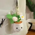 Cute plush potted plant keychain with a smiley face hanging on a cream backpack. - White Strawberry Pendant / 12-16cm Pendant
