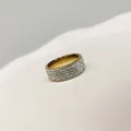 Nahaufnahme eines Edelstahlrings mit funkelndem Vollpavé-Strassbesatz in Goldoptik - Größe 7 / Gold