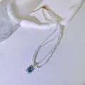 Detailansicht einer zweireihigen Perlenkette mit blauem Emaille-Blumenanhänger - Blaue Tulpe