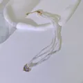 Detailansicht einer dreireihigen Perlenkette mit einem Vintage-Emaille-Herzanhänger - Lila Herz