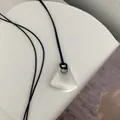 Minimalistische Kette mit unregelmäßigem mattweißem Anhänger an einer schwarzen Kordel. - Matte Fächerform / Silber + Schwarze Wachskordel