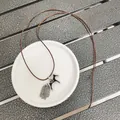 Detailansicht der Vintage-Pferde-Halskette mit silbernen Fransen und braunem Lederband - Kaffeebraunes Seil / Schwarzes Pony