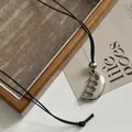 Vista detallada del exclusivo colgante de peine plateado en un cordón negro fino. - Cordón de cera negro / Plateado