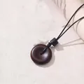 Retro minimalistische Halskette mit dunkelbraunem Donut-Anhänger und schwarzer Kordel - Friedensschnalle-Stil / Braunrot