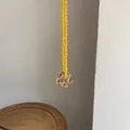 Primo piano di una collana di perline gialle con un ciondolo a forma di fiore in vetro - 40+5cm / Catena di Perline Gialle Fiore Arancione