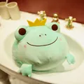 Detailed view of a soft mint green crown frog plush toy sitting inside a white sink - Green / 35cm