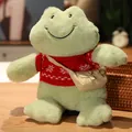 Peluche de rana verde sonriente con suéter rojo de copos de nieve y un bolso - Suéter Rojo con Copos de Nieve / Longitud total 30cm, altura sentada 26cm