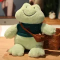 Lindo peluche de rana verde sonriente con suéter de punto y bolso marrón - Suéter Verde con Renos / Longitud total 30cm, altura sentada 26cm