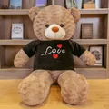 Giant plush teddy bear in black Love t-shirt sitting by a cozy bookshelf - 0.8m (1kg) / Dark Brown Black Sweatshirt