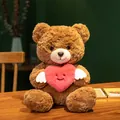 Süßer brauner Teddybär aus Plüsch mit einem rosa geflügelten Herz auf Holztisch - 25cm / Brauner Engel Herz Bär